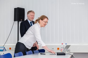Eine Frau und ein Mann während einer Präsentation auf der CBMI-Konferenz.