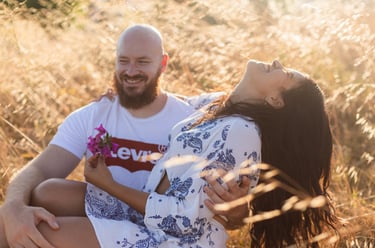 a man and woman sitting on a field