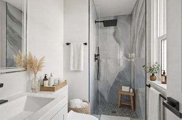 Bright renovated bathroom in Northern VA with frameless glass shower, marble‑style tile, and brushed