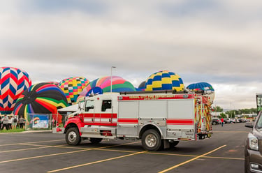 Vernal City Fire Department truck parked near colorful hot air balloons at a local community festival.