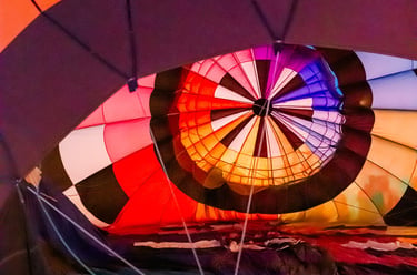 Interior view of a colorful hot air balloon being inflated with vibrant red, orange, and blue panels.