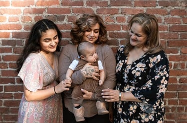 Imagen de tres mujeres sosteniendo a un bebé,