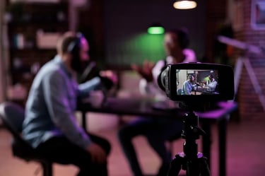 Video camera recording two guests talking on a podcast set at Miami Creator Studio.