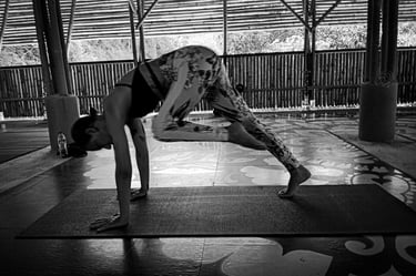 A woman transitions from Downward to Warrior One in Yoga practice