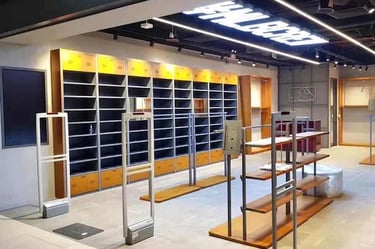 Empty MLB retail store interior with display shelves, clothing racks, and security gates.