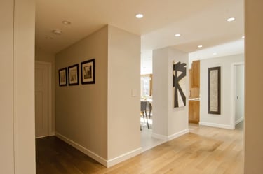 a hallway with a wooden floor and a picture of a person walking through the hallway