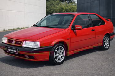 Fiat Tempra Turbo 1995 vermelho em foto lateral com placa personalizada TEMPRA e fundo moderno