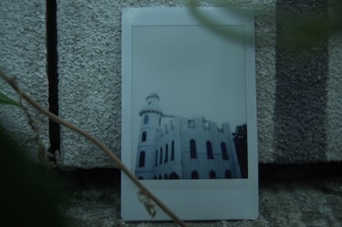 Photograph of a white castle placed against a stone wall, still from Nostalgia by Tina Bikic.