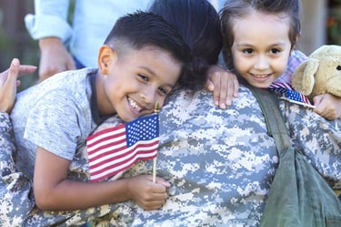 a soldier soldier is holding a teddy bear