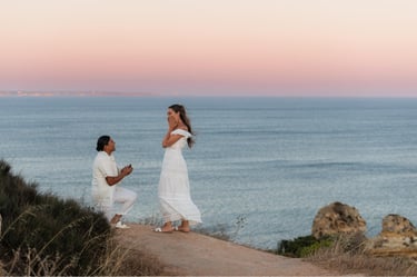 a man proposing a woman on a cliff overlooking the ocean