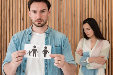 Homme tenant une image d'une familledéchirée avecune femme triste en arriere plan