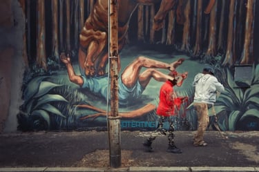 Expressive street photography artwork of men walking past a vivid mural of a tiger attacking a man in Woodstock, Cape Town
