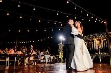 a bride and groom share a first dance at their wedding reception