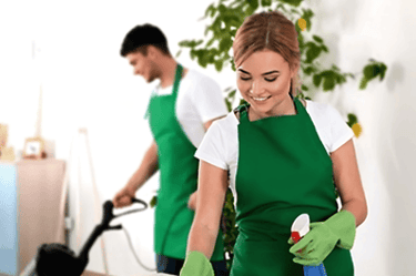 a man and woman cleaning a table