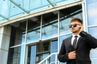 Force Prévention Sécurité – Agent de sécurité en costume noir, équipé d'oreillettes et de lunettes de soleil, assurant la sur