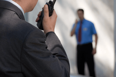Force Prévention Sécurité – Agent de sécurité en costume noir, équipé d'oreillettes et de lunettes de soleil, assurant la sur