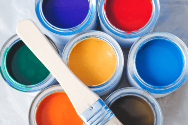 a paintbrush and paint cans of different colors