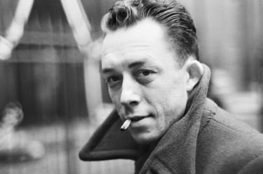 A black and white potrait of french writer ablert camus smoking a cigarette.