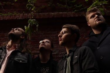 Le groupe Rush On Mars regardant à l'horizon sur un fond de brique