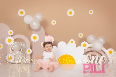 two babies are sitting on a table with balloons and balloons