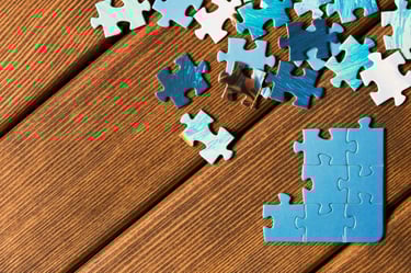 Puzzle pieces on brown floor.