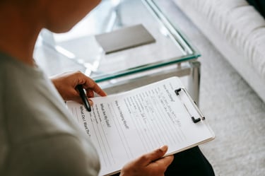 a woman is holding a pen and writing on a notepad