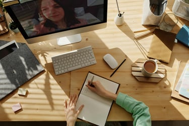 a person sitting at a desk with a laptop and a computer
