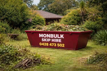 overgrown front yard of a house with a maroon monbulk skip bin loaded with green waste