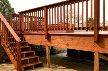 Completed residential wooden deck with stairs leading to a yard, built by Brewer Construction in Golden.