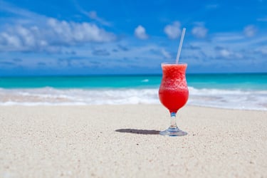 a glass of red wine on the beach