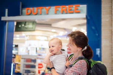 Young mother with baby in Duty Free at airport