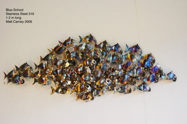 a school of fish sculpture on a wall