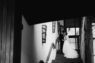 a bride and groom standing on stairs in a black and white photo