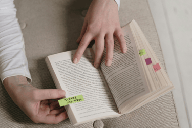 A book with pages marked with colorful sticky tabs