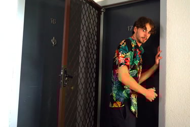a man in a hawaiian shirt is standing in a doorway