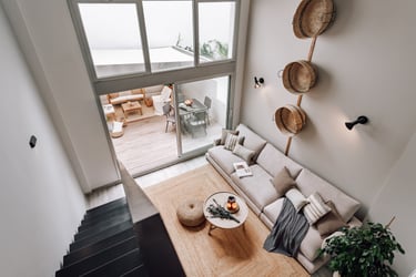 Modern living room with an iron staircase, natural wood finishes in Barcelona interior design