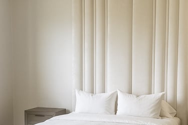 Bedroom with vertical upholstered wall panels in a soft neutral tone by Solo Home Decor