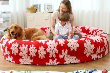 a woman and a dog  sitting on a  human size dog bed