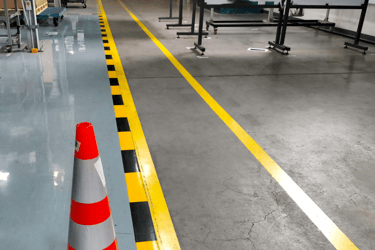 Suelo de una fabrica con las líneas pintadas de amarillo y negro.