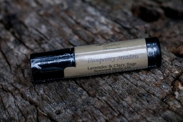 body oil in black vial on a tree stump