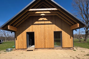 a wooden structure with a shadow of a person standing in front of a tree