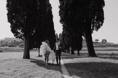 a bride and groom walking down a path in a field