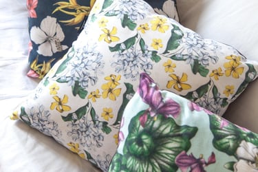 Four Pillows with multicolor hand-drawn floral patterns on a white couch