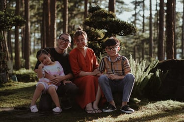 a family sitting on a bench in a park