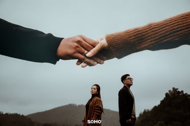 a man and woman holding hands in front of a mountain