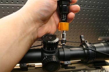 Image link of tightening a screw on a scope ring linking to a blog post about torque specs