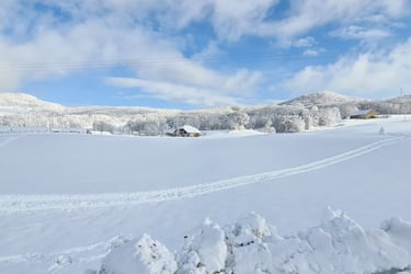 a snow covered field with a ski lift in the background