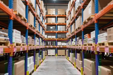 Warehouse aisle with boxes on tall industrial pallet racking systems for storage and distribution.
