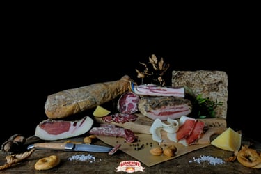 Selection of Italian cured meats like capicola and pancetta with cheese on a rustic board.