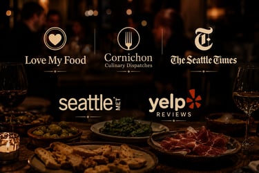 Spanish tapas and wine on a table with press logos from Seattle Met and The Seattle Times.